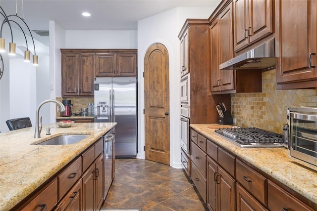15203 Lariat Trl, Austin, TX 78734 - kitchen featuring stainless steel appliances, under cabinet range hood, light stone counters, decorative backsplash, and recessed lighting
