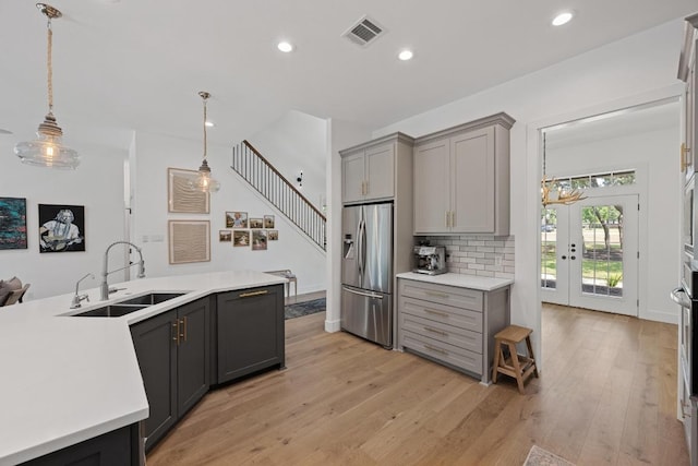 140 Vincas Shadow Ct, Driftwood, TX 78619 - kitchen featuring a sink, stainless steel fridge, gray cabinetry, light countertops, and light wood-style flooring