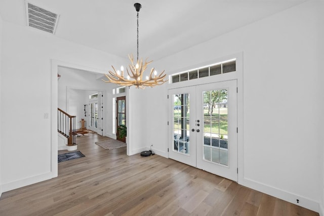 140 Vincas Shadow Ct, Driftwood, TX 78619 - unfurnished dining area with french doors, a chandelier, wood finished floors, baseboards, and stairway