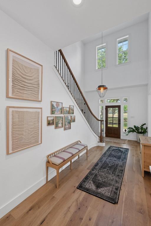 140 Vincas Shadow Ct, Driftwood, TX 78619 - entrance foyer with a high ceiling, baseboards, stairs, and wood finished floors