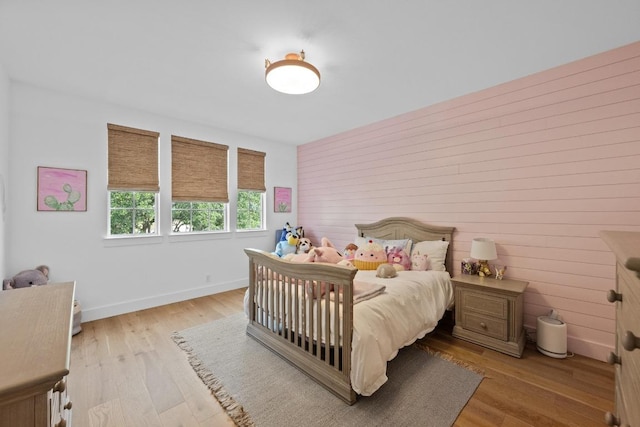 140 Vincas Shadow Ct, Driftwood, TX 78619 - bedroom with baseboards, light wood finished floors, and wooden walls
