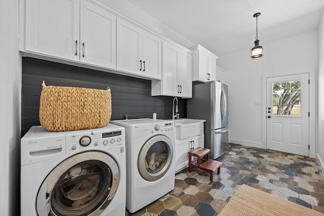 140 Vincas Shadow Ct, Driftwood, TX 78619 - washroom featuring washing machine and clothes dryer, cabinet space, stone finish flooring, and baseboards
