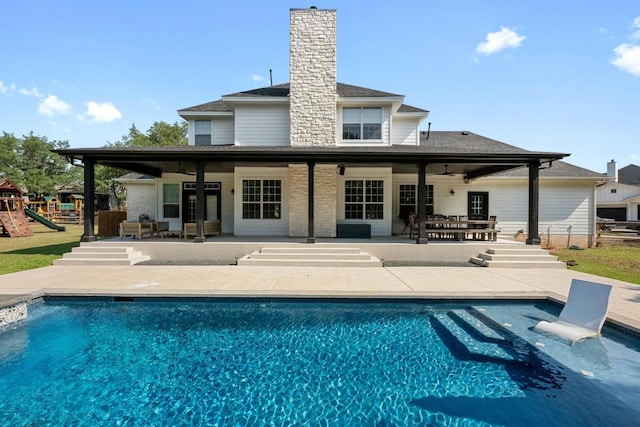 140 Vincas Shadow Ct, Driftwood, TX 78619 - rear view of house with ceiling fan, a patio, a playground, and an outdoor pool