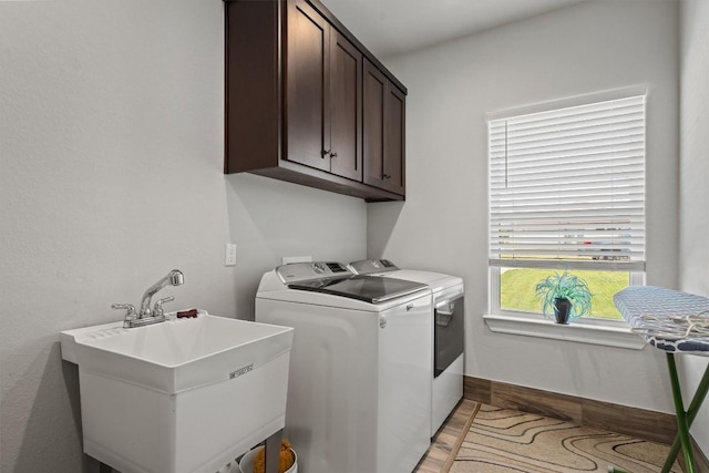 308 First Down Dash, Burnet, TX 78611 - laundry room with independent washer and dryer, light wood-style floors, cabinet space, and baseboards