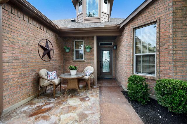 3200 Argento Pl, Cedar Park, TX 78613 - property entrance with brick siding, a patio, and a shingled roof