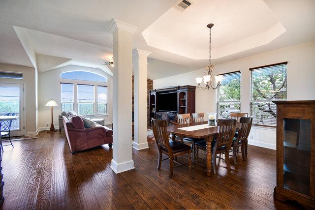 3200 Argento Pl, Cedar Park, TX 78613 - dining room with plenty of natural light, a tray ceiling, and dark wood finished floors