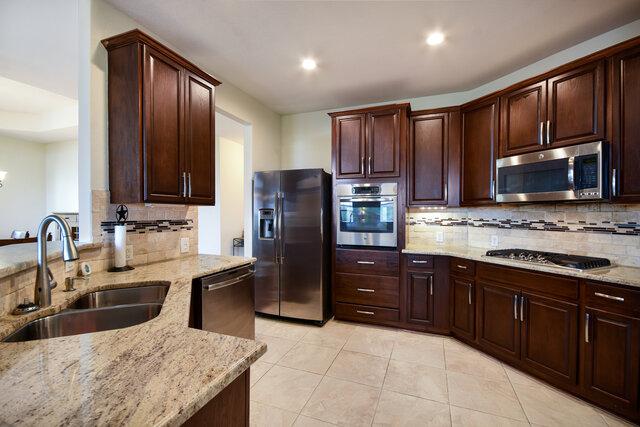 3200 Argento Pl, Cedar Park, TX 78613 - kitchen featuring appliances with stainless steel finishes, a sink, light stone countertops, backsplash, and recessed lighting