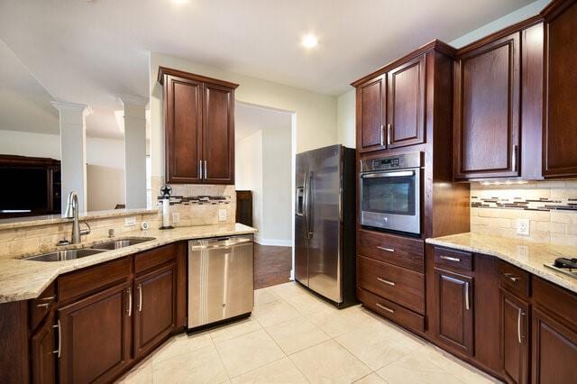 3200 Argento Pl, Cedar Park, TX 78613 - kitchen with appliances with stainless steel finishes, a sink, backsplash, light stone countertops, and recessed lighting