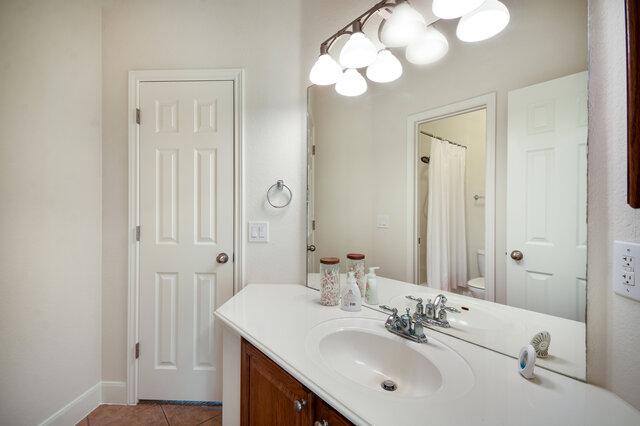 3200 Argento Pl, Cedar Park, TX 78613 - bathroom with vanity, toilet, tile patterned flooring, baseboards, and a chandelier