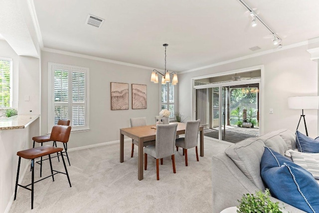 103 Winecup Way, Georgetown, TX 78633 - dining area featuring ornamental molding, light carpet, rail lighting, a chandelier, and plenty of natural light
