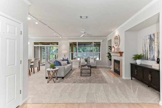 103 Winecup Way, Georgetown, TX 78633 - living area with light colored carpet, rail lighting, a ceiling fan, ornamental molding, and a tile fireplace