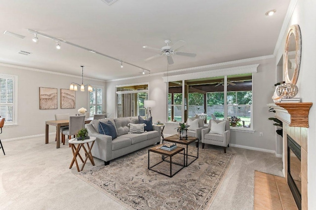 103 Winecup Way, Georgetown, TX 78633 - living area featuring light carpet, a fireplace with flush hearth, crown molding, baseboards, and track lighting