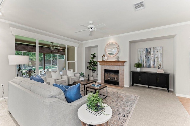 103 Winecup Way, Georgetown, TX 78633 - living area featuring a ceiling fan, ornamental molding, baseboards, a tiled fireplace, and carpet floors