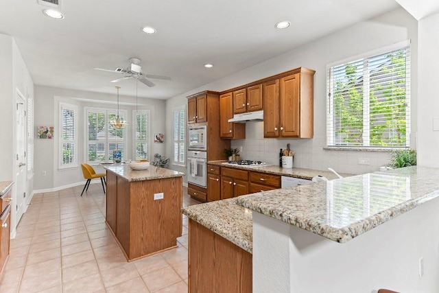 103 Winecup Way, Georgetown, TX 78633 - kitchen with a ceiling fan, brown cabinetry, white appliances, light tile patterned flooring, and tasteful backsplash