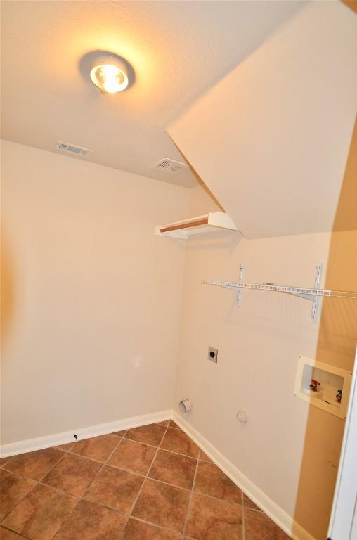 12609 Lee Park Ln, Austin, TX 78732 - laundry area featuring washer hookup, hookup for an electric dryer, baseboards, gas dryer hookup, and tile patterned floors