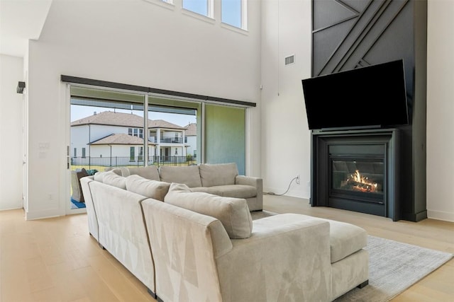 2905 Canto Trce, Leander, TX 78641 - living room with a towering ceiling, light wood-type flooring, and a glass covered fireplace