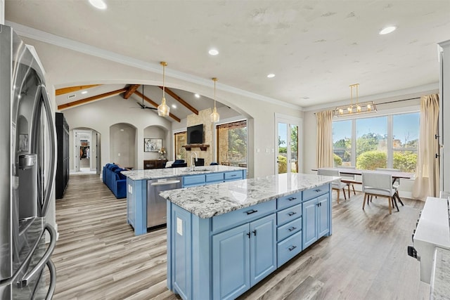 101 Aldea St, Georgetown, TX 78633 - kitchen with appliances with stainless steel finishes, a center island, blue cabinets, arched walkways, and recessed lighting