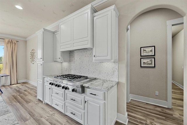 101 Aldea St, Georgetown, TX 78633 - kitchen with stainless steel gas cooktop, arched walkways, light wood finished floors, and recessed lighting