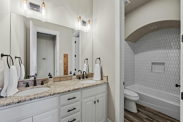 101 Aldea St, Georgetown, TX 78633 - bathroom featuring wood finished floors, double vanity, and washtub / shower combination