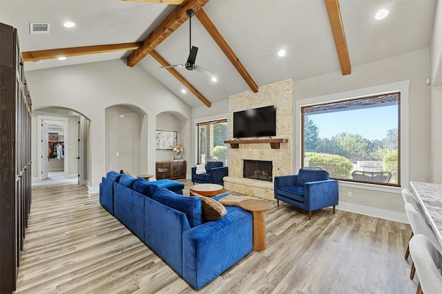 101 Aldea St, Georgetown, TX 78633 - living room featuring light wood-style flooring, beam ceiling, ceiling fan, plenty of natural light, and a stone fireplace