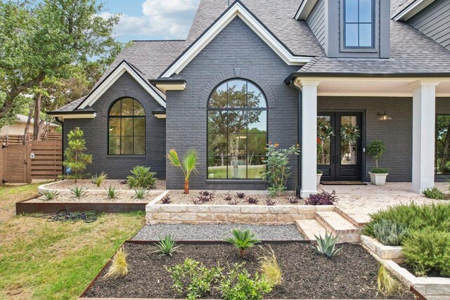 400 Goodnight Trl, Dripping Springs, TX 78620 - view of exterior entry with brick siding, french doors, and roof with shingles