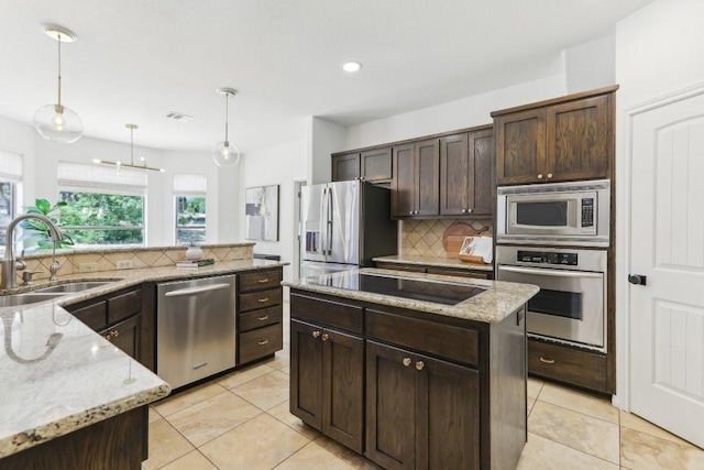 400 Goodnight Trl, Dripping Springs, TX 78620 - kitchen featuring appliances with stainless steel finishes, a sink, backsplash, dark brown cabinets, and decorative light fixtures