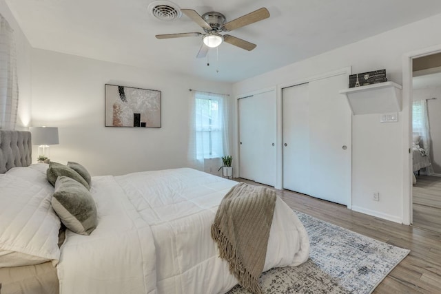3002 Stardust Dr, Austin, TX 78757 - bedroom with two closets, multiple windows, wood finished floors, and baseboards