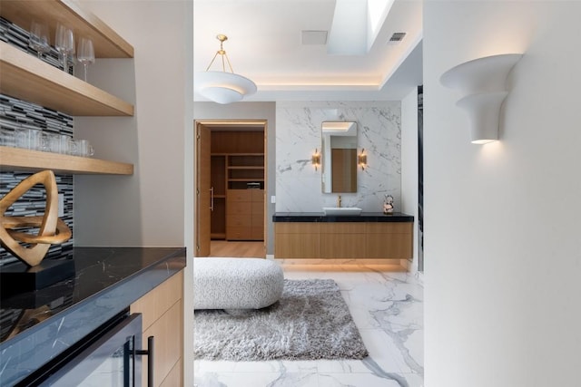 1115 Gillespie Pl, Austin, TX 78704 - bathroom with vanity, marble tiled floors, and beverage cooler