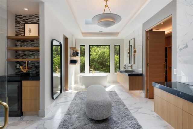 1115 Gillespie Pl, Austin, TX 78704 - bathroom featuring vanity, marble tiled flooring, a soaking tub, and a raised ceiling