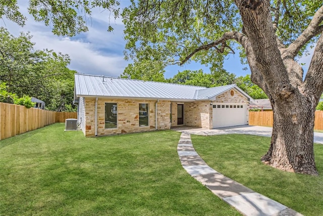 5403 Village Ln, Austin, TX 78744 - view of front facade featuring central AC unit, driveway, an attached garage, metal roof, and brick siding