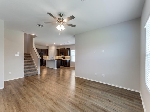 204 Magione St, Hutto, TX 78634 - unfurnished living room with a ceiling fan, baseboards, wood finished floors, stairway, and recessed lighting