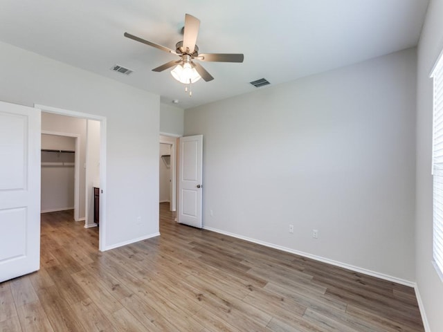 204 Magione St, Hutto, TX 78634 - unfurnished bedroom with light wood finished floors, a walk in closet, a closet, and baseboards