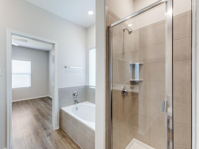 204 Magione St, Hutto, TX 78634 - full bathroom with a bath, a stall shower, wood finished floors, and baseboards