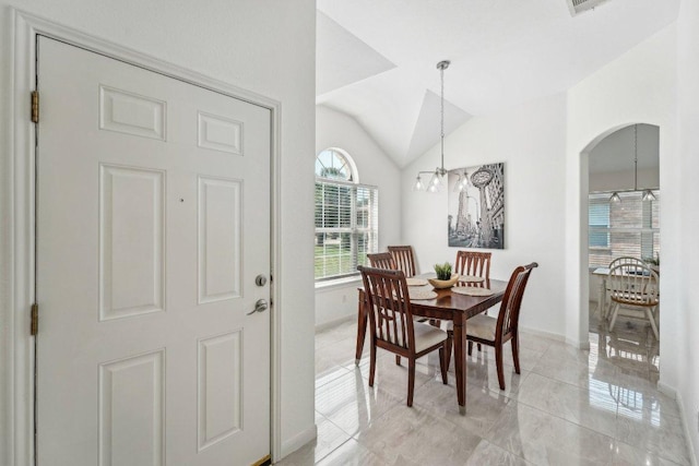 6015 Lone Star Ct, Hutto, TX 78634 - dining area with lofted ceiling, a chandelier, arched walkways, and light tile patterned flooring