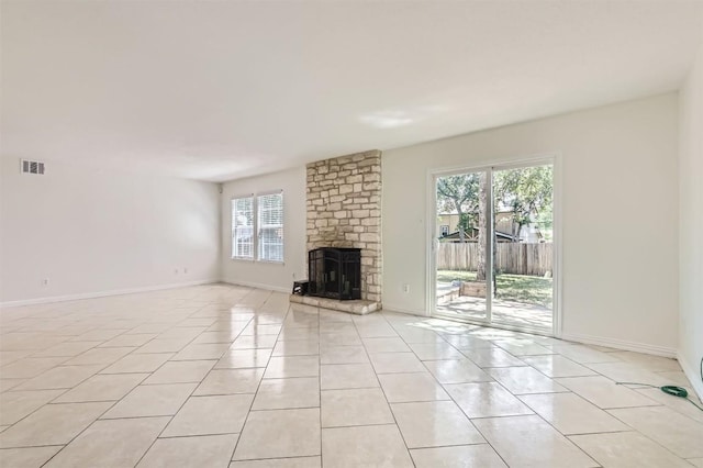 11619 Birchbark Trl, Austin, TX 78750 - unfurnished living room with plenty of natural light, light tile patterned floors, a stone fireplace, and baseboards