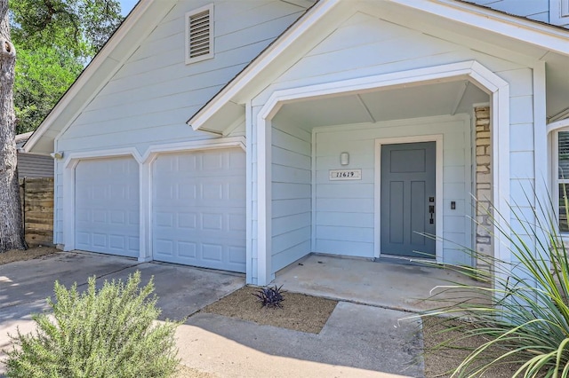 11619 Birchbark Trl, Austin, TX 78750 - view of exterior entry with concrete driveway and a garage