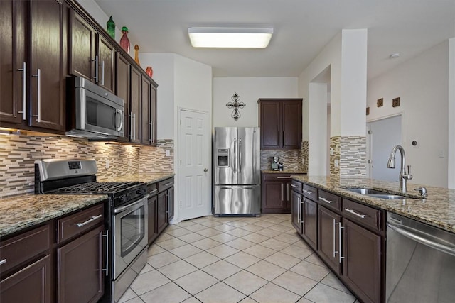 15617 Staffordshire Ln, Austin, TX 78717 - kitchen with stainless steel appliances, a sink, stone counters, tasteful backsplash, and dark brown cabinetry