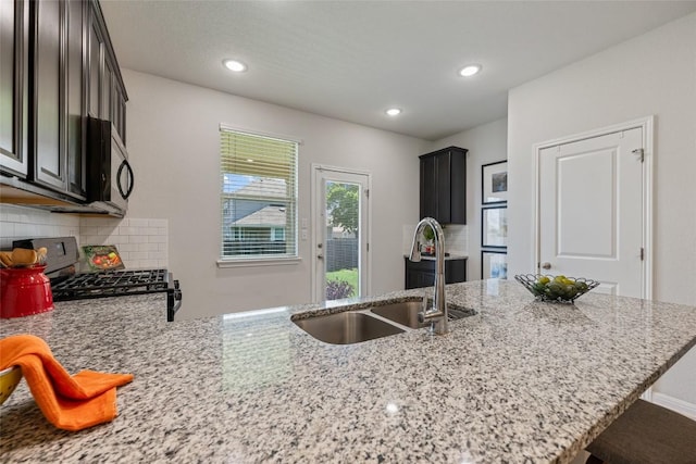 212 Canis St, Georgetown, TX 78628 - kitchen with a sink, range with gas cooktop, light stone countertops, decorative backsplash, and recessed lighting
