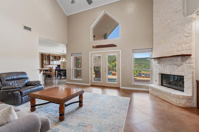 17505 E Darleen Dr, Leander, TX 78641 - living room with tile patterned floors, crown molding, a stone fireplace, a high ceiling, and ceiling fan