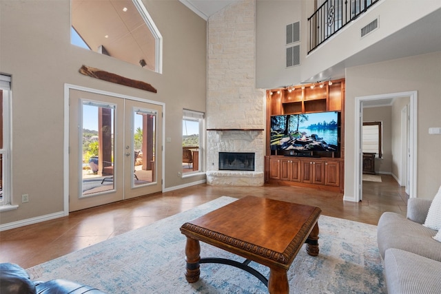 17505 E Darleen Dr, Leander, TX 78641 - living room with light tile patterned floors, high vaulted ceiling, french doors, baseboards, and a stone fireplace