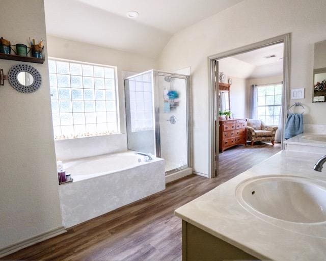 1406 Apache Cv, Pflugerville, TX 78660 - bathroom featuring double vanity, wood finished floors, a garden tub, a stall shower, and vaulted ceiling