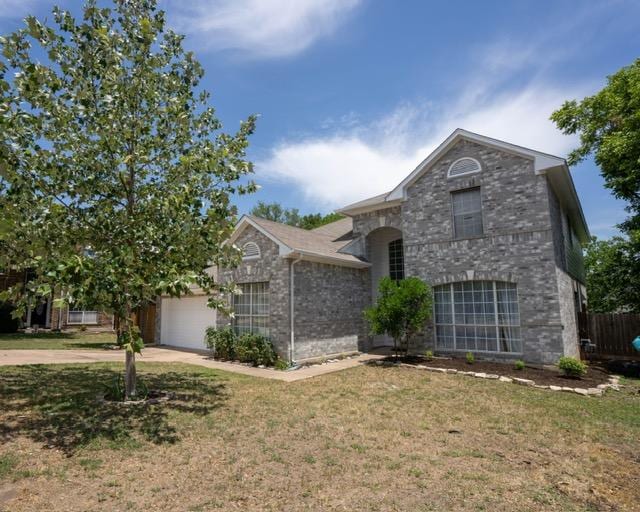 1406 Apache Cv, Pflugerville, TX 78660 - view of front facade with a garage, a front yard, driveway, and brick siding
