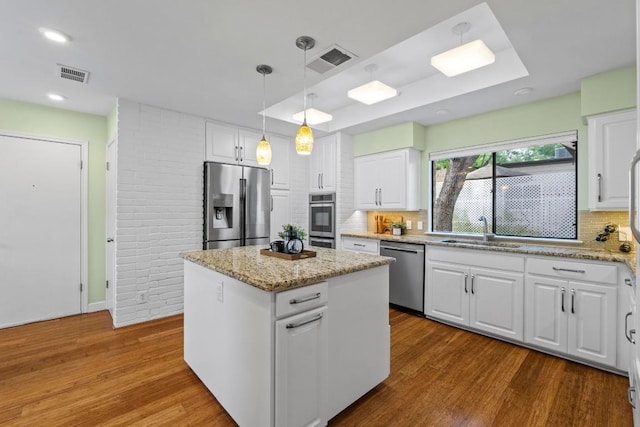 8126 Greenslope Dr, Austin, TX 78759 - kitchen featuring stainless steel appliances, a sink, wood finished floors, decorative backsplash, and white cabinets