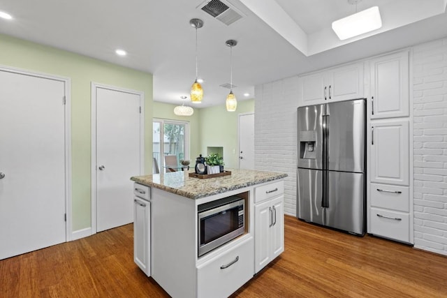 8126 Greenslope Dr, Austin, TX 78759 - kitchen with stainless steel appliances, wood finished floors, white cabinetry, hanging light fixtures, and recessed lighting