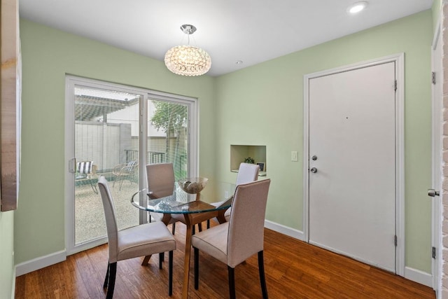 8126 Greenslope Dr, Austin, TX 78759 - dining area with a chandelier, baseboards, and wood finished floors