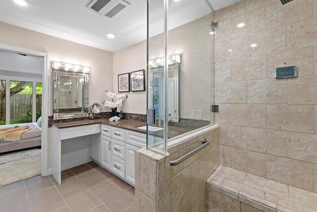 8126 Greenslope Dr, Austin, TX 78759 - ensuite bathroom with tiled shower, vanity, recessed lighting, and tile patterned flooring
