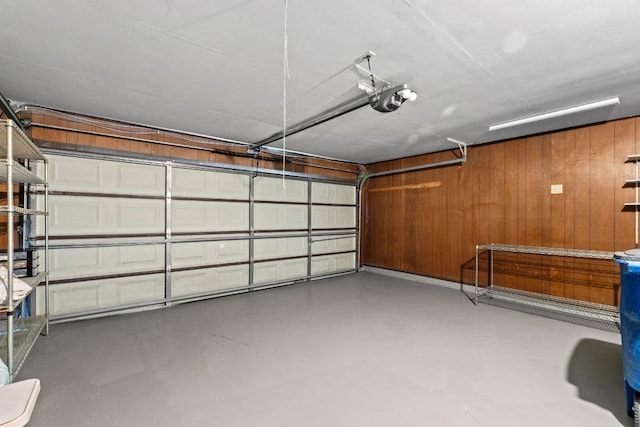8126 Greenslope Dr, Austin, TX 78759 - garage featuring a garage door opener and wood walls