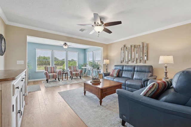 709 Kitty Hawk Rd, Georgetown, TX 78633 - living area featuring light wood-type flooring, ceiling fan, crown molding, baseboards, and a textured ceiling