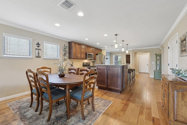 709 Kitty Hawk Rd, Georgetown, TX 78633 - dining space with ornamental molding, light wood finished floors, baseboards, recessed lighting, and a textured ceiling