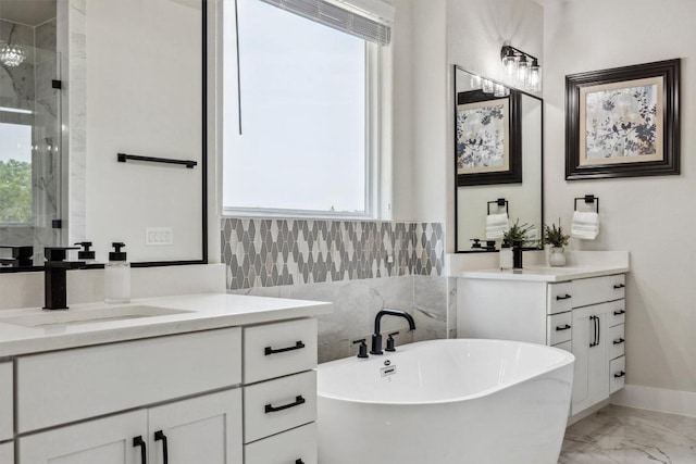 2 Basswood Cir, Wimberley, TX 78676 - bathroom with marble look tile flooring, two vanities, a stall shower, a freestanding bath, and baseboards